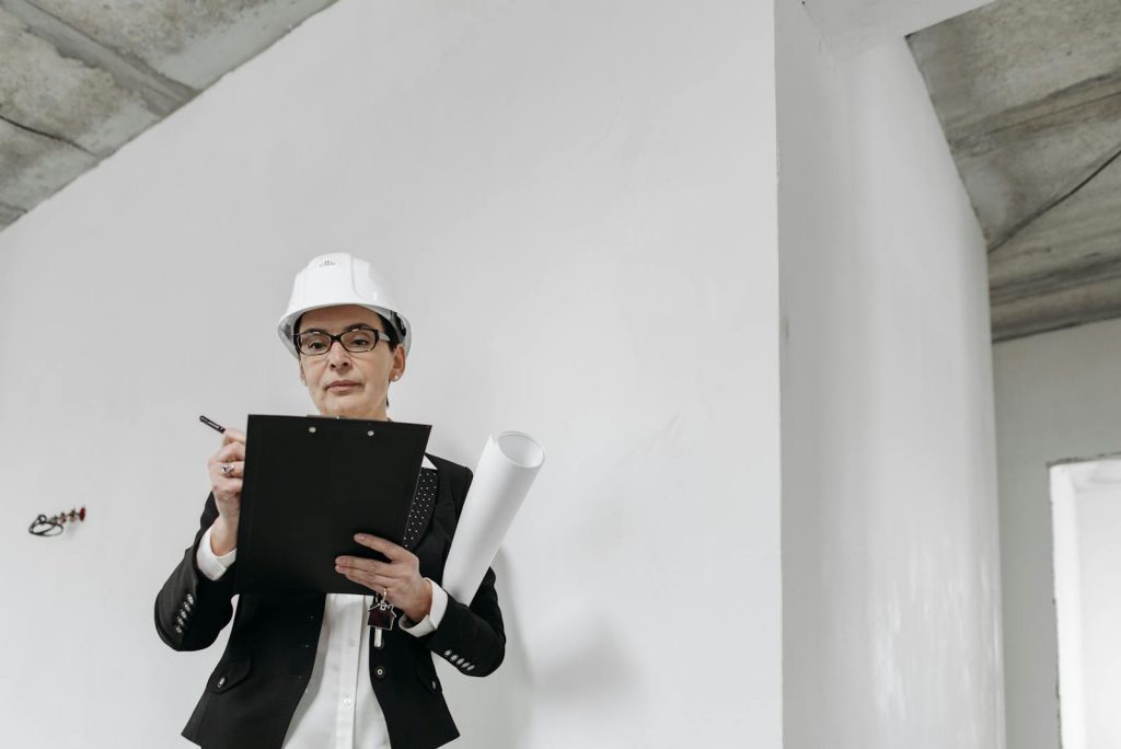 Engineer in Helmet Writing in Notepad